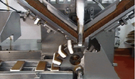 A machine rapidly producing ice cream sandwiches